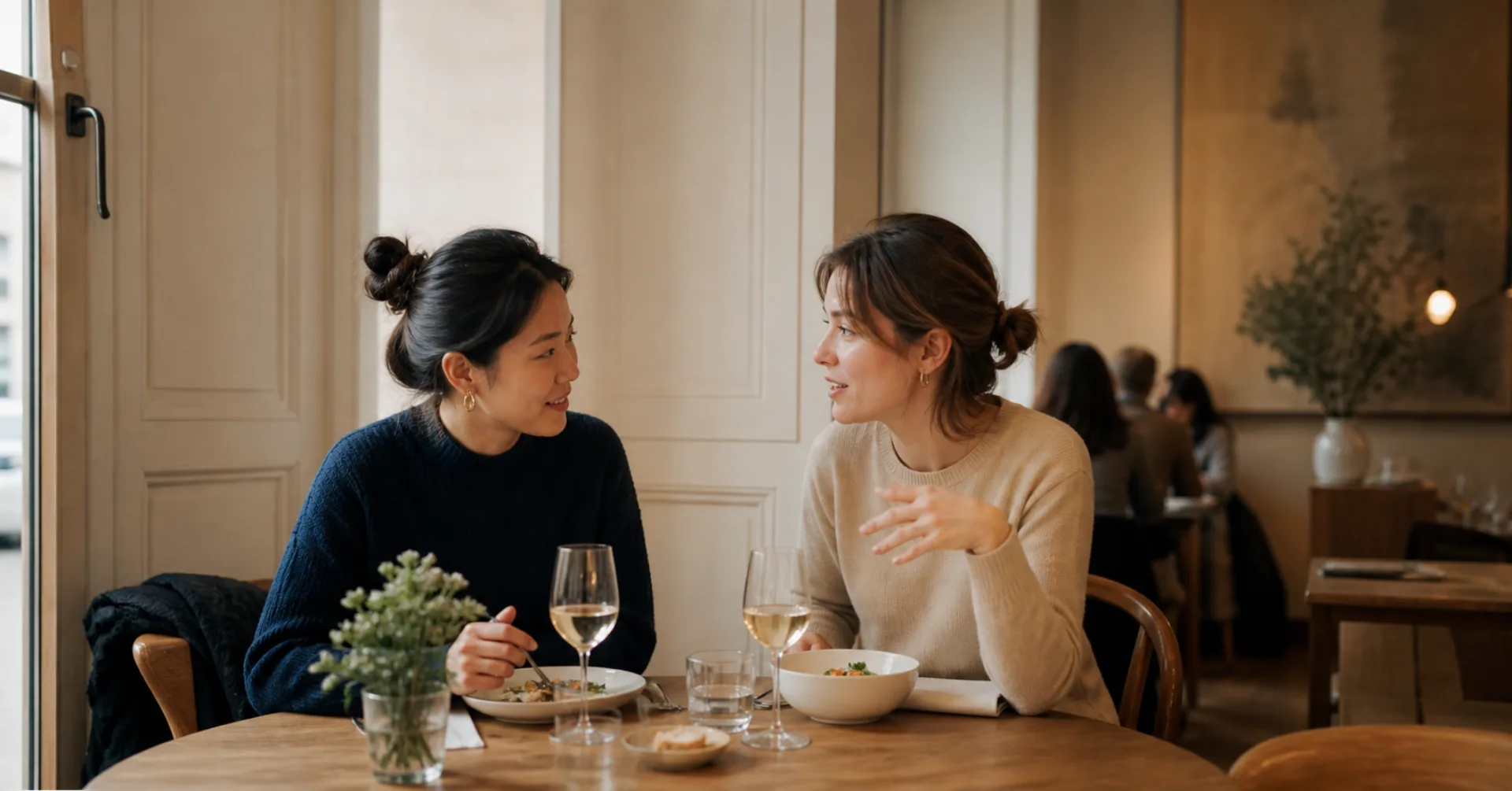 Zwei Freundinnen im Gespräch beim Mittagessen in einem europäischen Restaurant